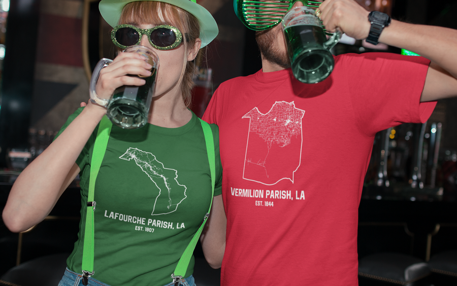 Two people in festive hats and sunglasses drinking at a bar.
